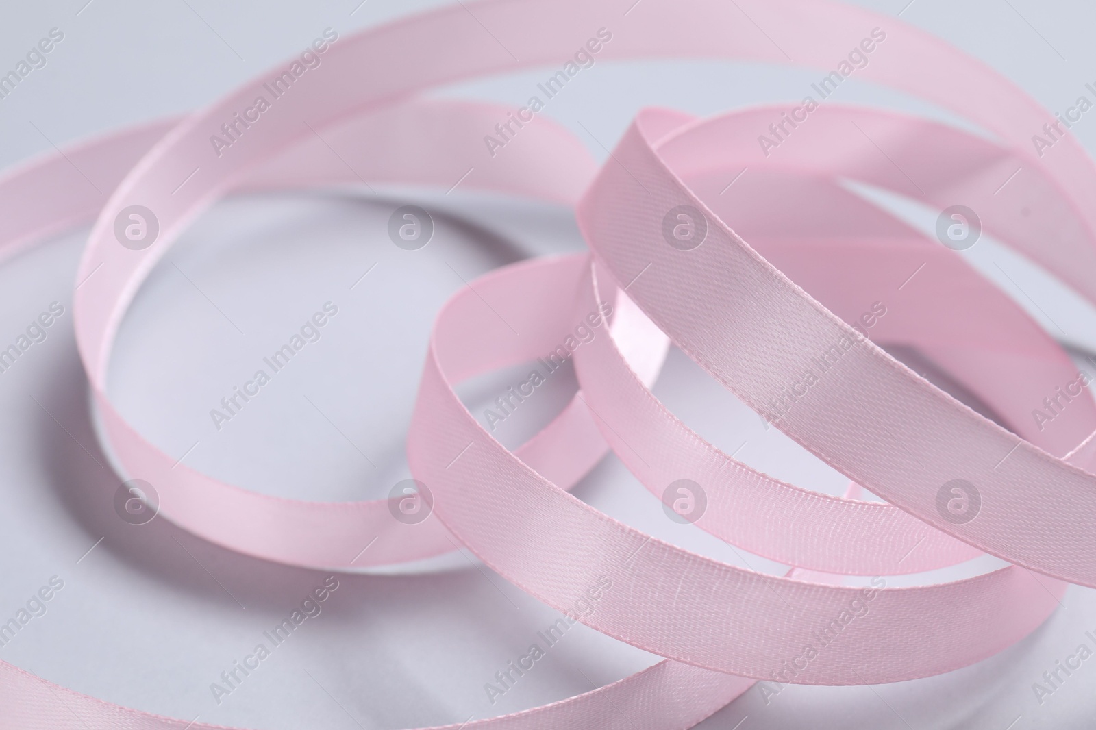 Photo of One beautiful pink ribbon on white background, closeup