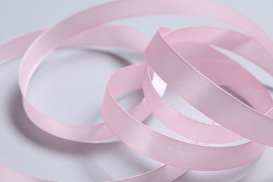 Photo of One beautiful pink ribbon on white background, closeup