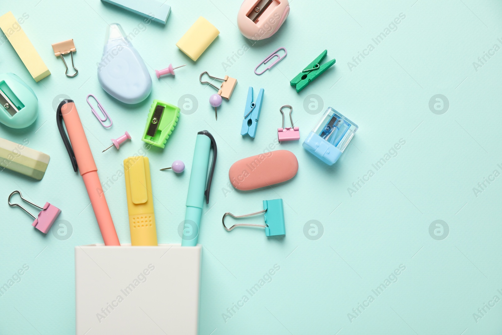 Photo of Flat lay composition with holder and different stationery on turquoise background, space for text