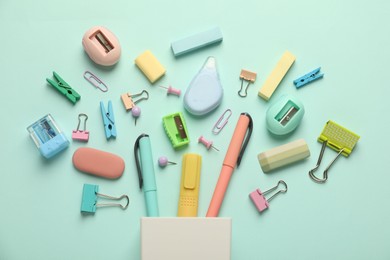 Photo of Flat lay composition with holder and different stationery on turquoise background