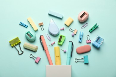 Flat lay composition with holder and different stationery on turquoise background