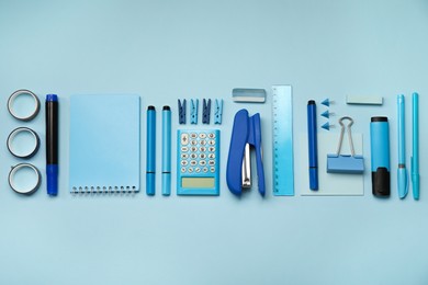 Flat lay composition with notebook, stapler and different stationery on light blue background