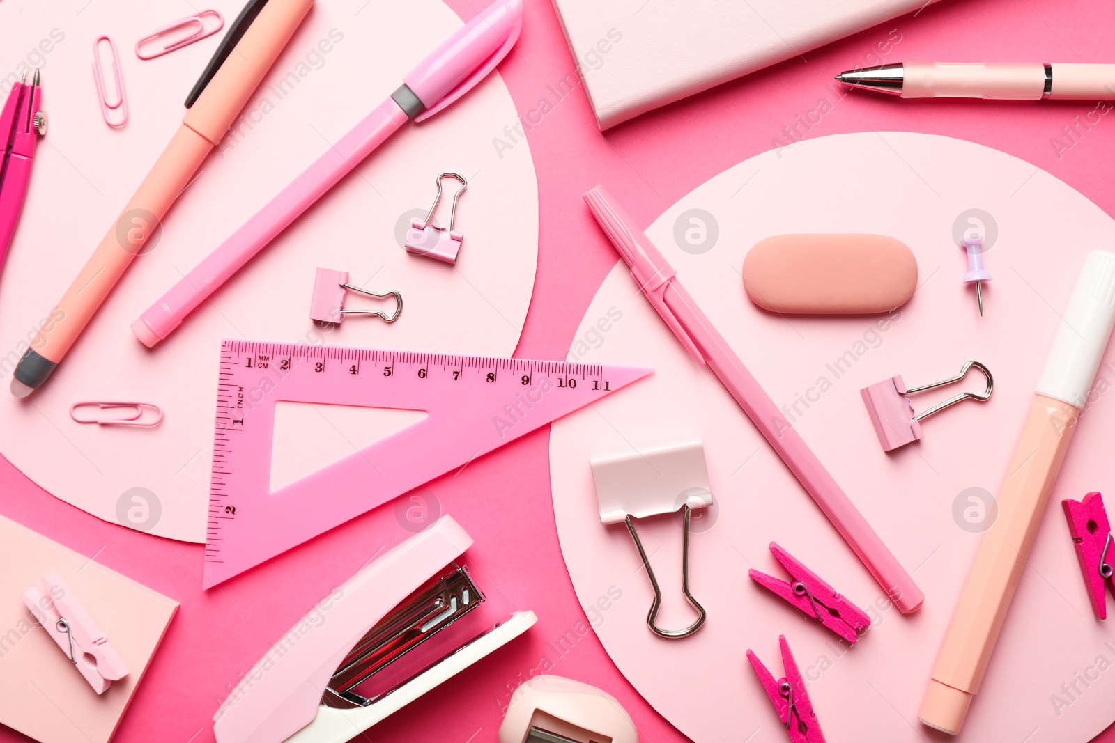 Photo of Flat lay composition with stapler and different stationery on pink background