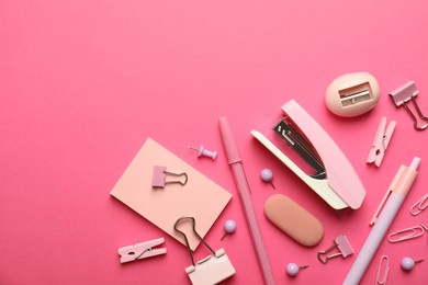 Flat lay composition with stapler and different stationery on pink background, space for text