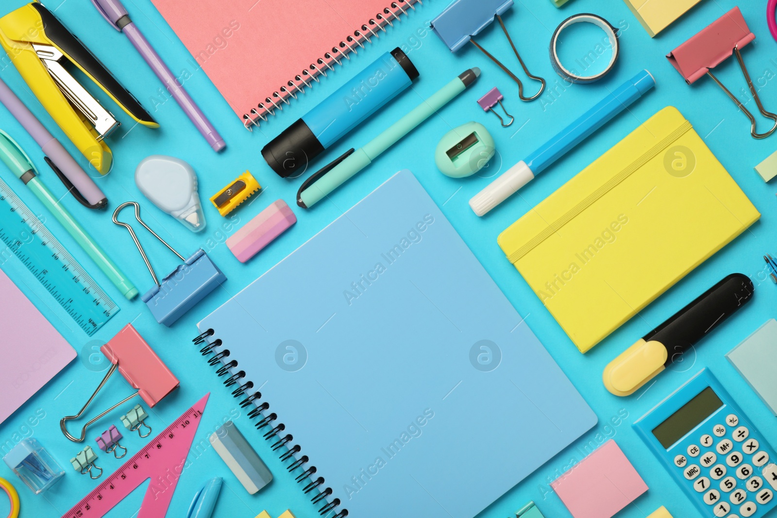 Photo of Flat lay composition with notebook and different stationery on light blue background