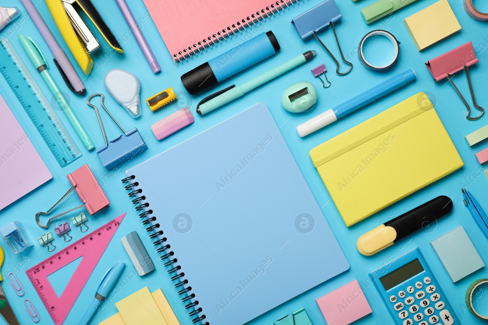 Photo of Flat lay composition with notebook and different stationery on light blue background