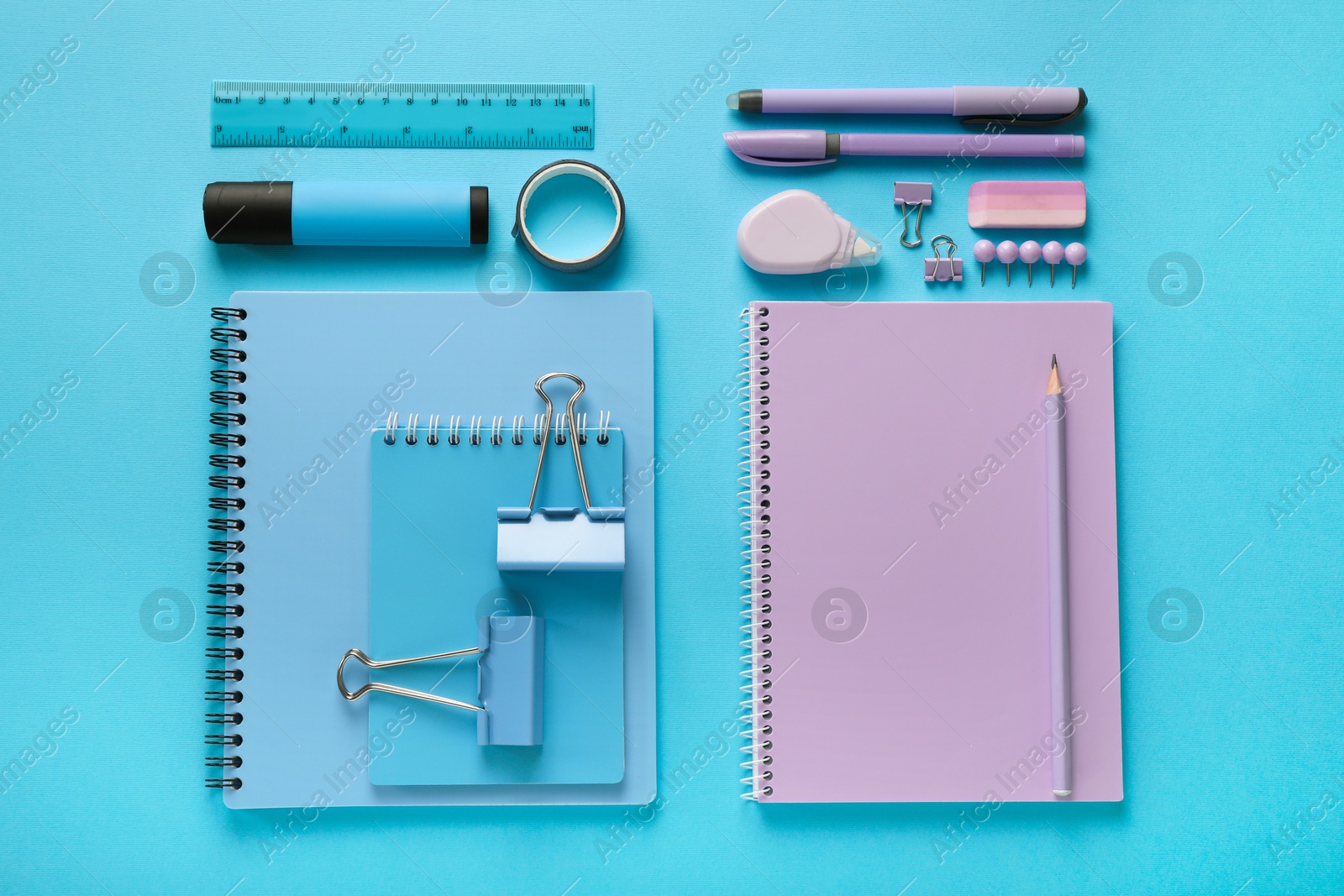 Photo of Flat lay composition with notebooks and different stationery on light blue background