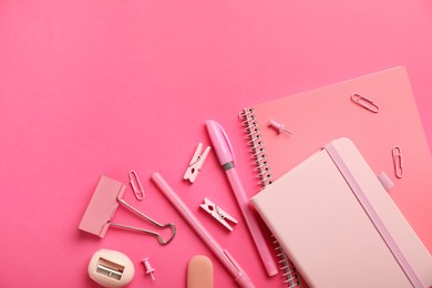 Flat lay composition with notebooks and different stationery on pink background, space for text