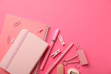 Photo of Flat lay composition with notebooks and different stationery on pink background, space for text