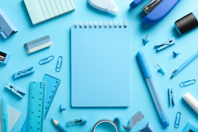 Flat lay composition with notebook, stapler and different stationery on light blue background