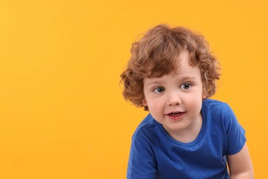 Photo of Portrait of cute little boy on yellow background, space for text