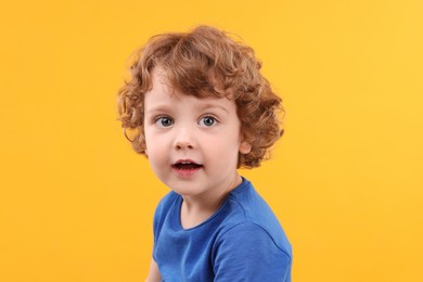 Photo of Portrait of cute little boy on yellow background