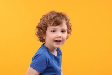 Photo of Portrait of cute little boy on yellow background