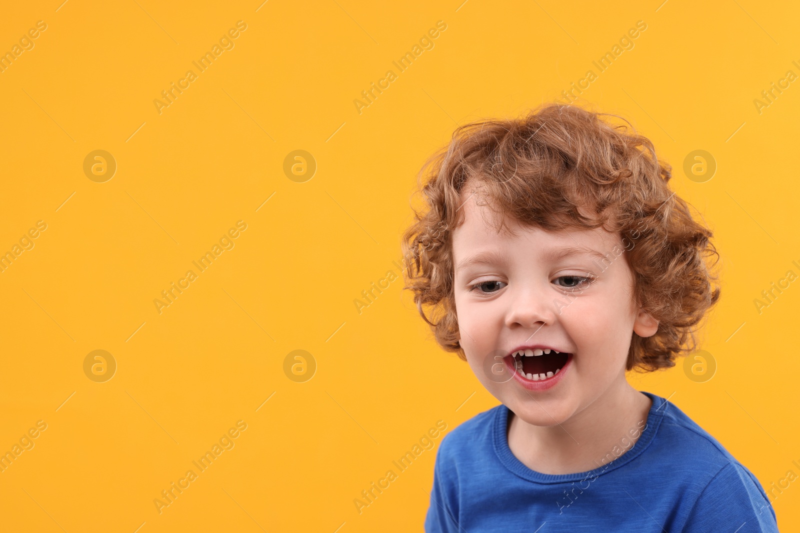 Photo of Portrait of emotional little boy on yellow background, space for text