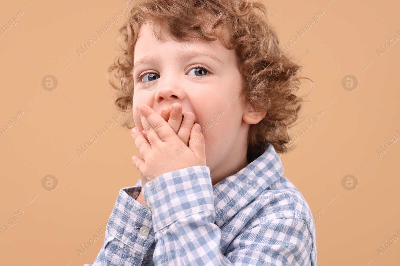 Photo of Portrait of cute little boy on beige background