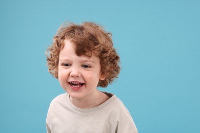 Portrait of cute little boy on light blue background