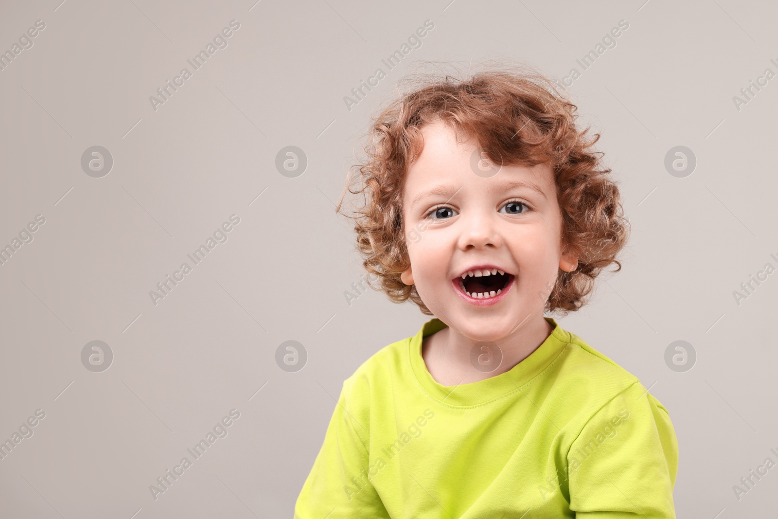 Photo of Portrait of cute little boy on grey background, space for text