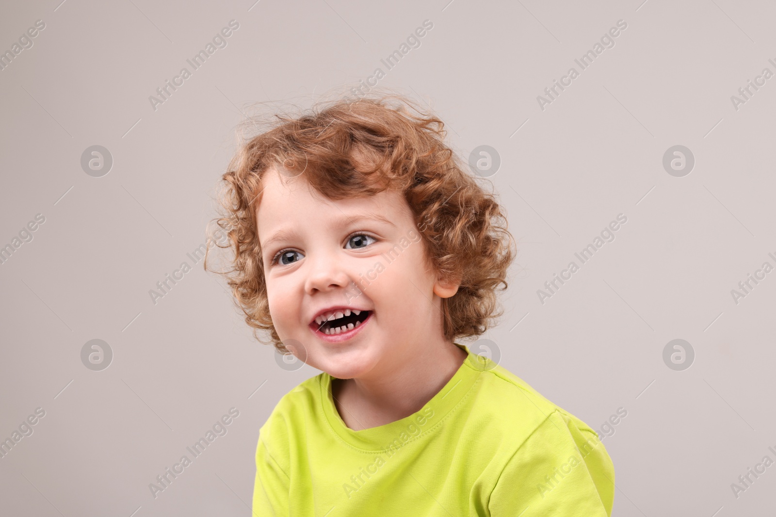 Photo of Portrait of cute little boy on grey background