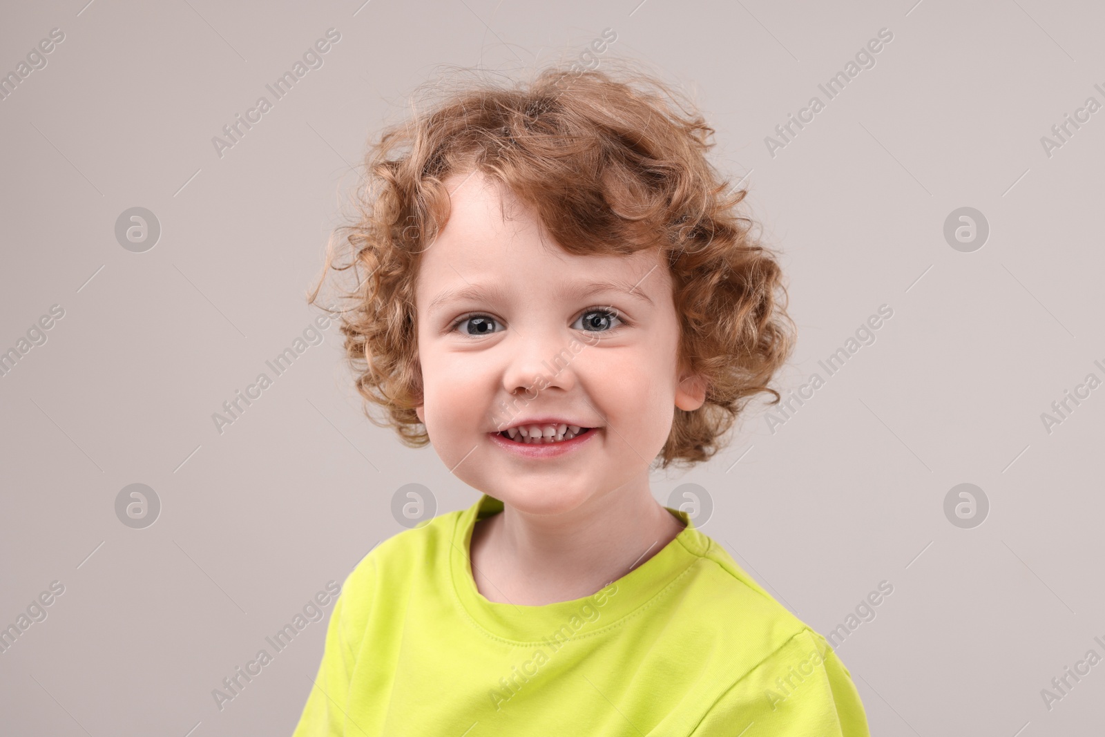 Photo of Portrait of cute little boy on grey background