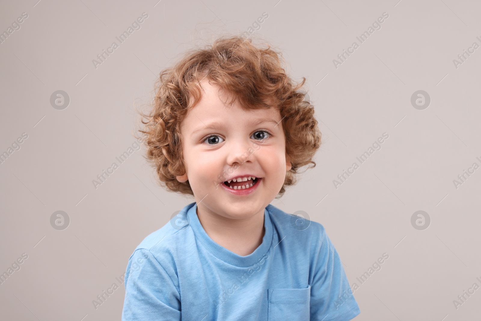 Photo of Portrait of cute little boy on grey background