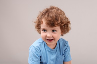 Portrait of cute little boy on grey background