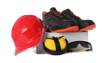 Photo of Pair of working boots, hard hat, earmuffs and goggles isolated on white