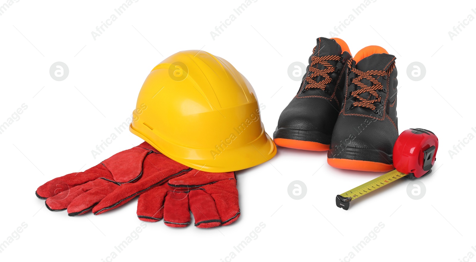 Photo of Pair of working boots, hard hat, protective gloves and measuring tape isolated on white