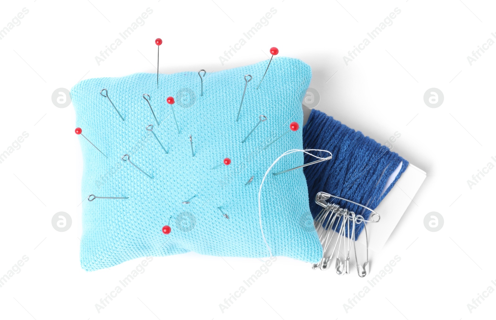 Photo of Light blue pincushion with sewing pins and threads isolated on white, top view