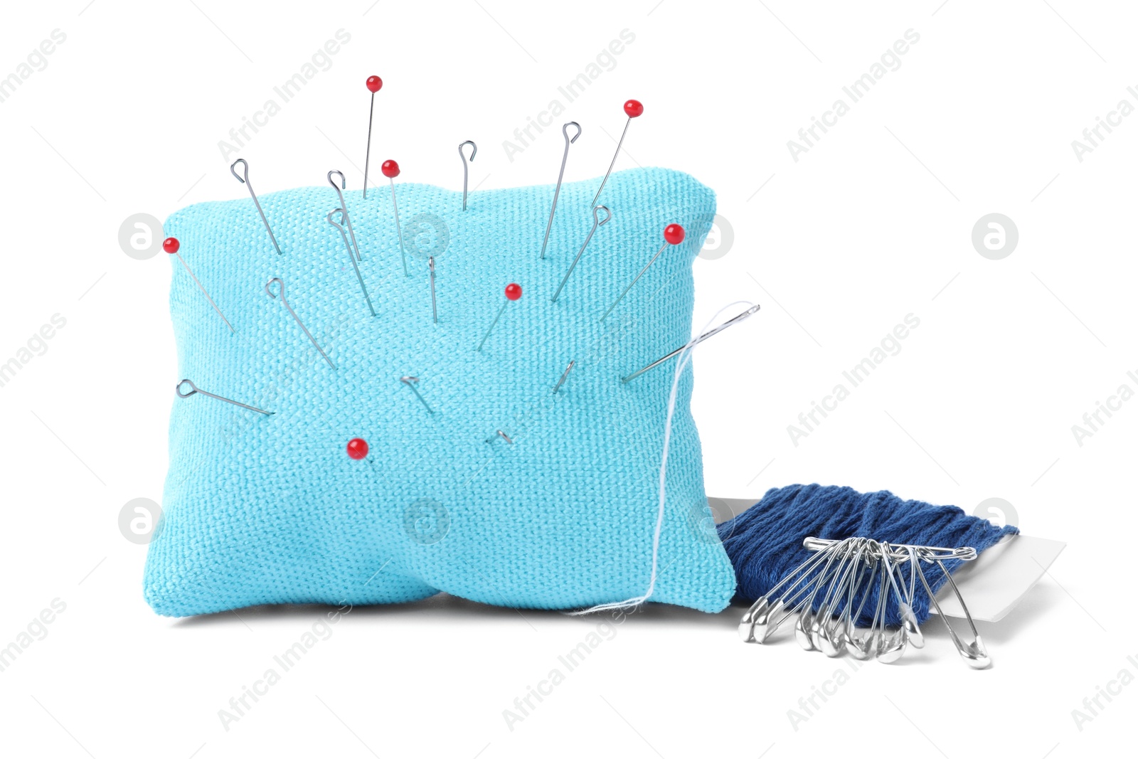 Photo of Light blue pincushion with sewing pins and threads isolated on white
