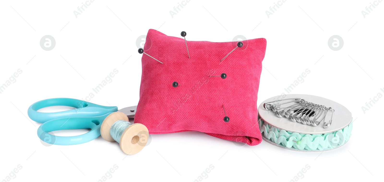 Photo of Pincushion, pins and other sewing tools isolated on white