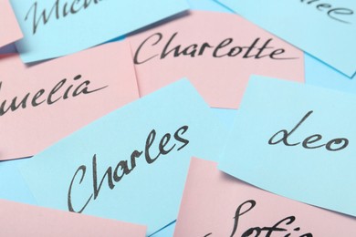 Photo of Paper stickers with different names, closeup. Choosing baby's name