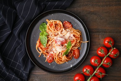 Photo of Tasty pasta with tomato sauce, cheese and basil on wooden table, flat lay