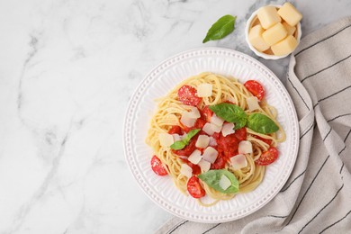 Tasty pasta with tomato sauce, cheese and basil on white marble table, flat lay. Space for text