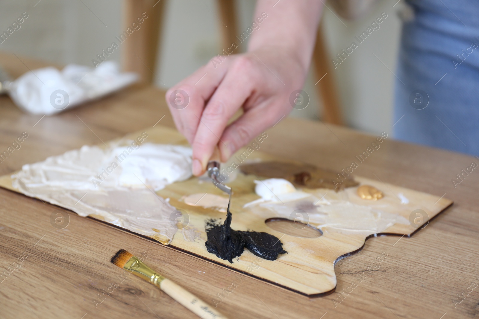 Photo of Woman with palette at table in drawing studio, closeup