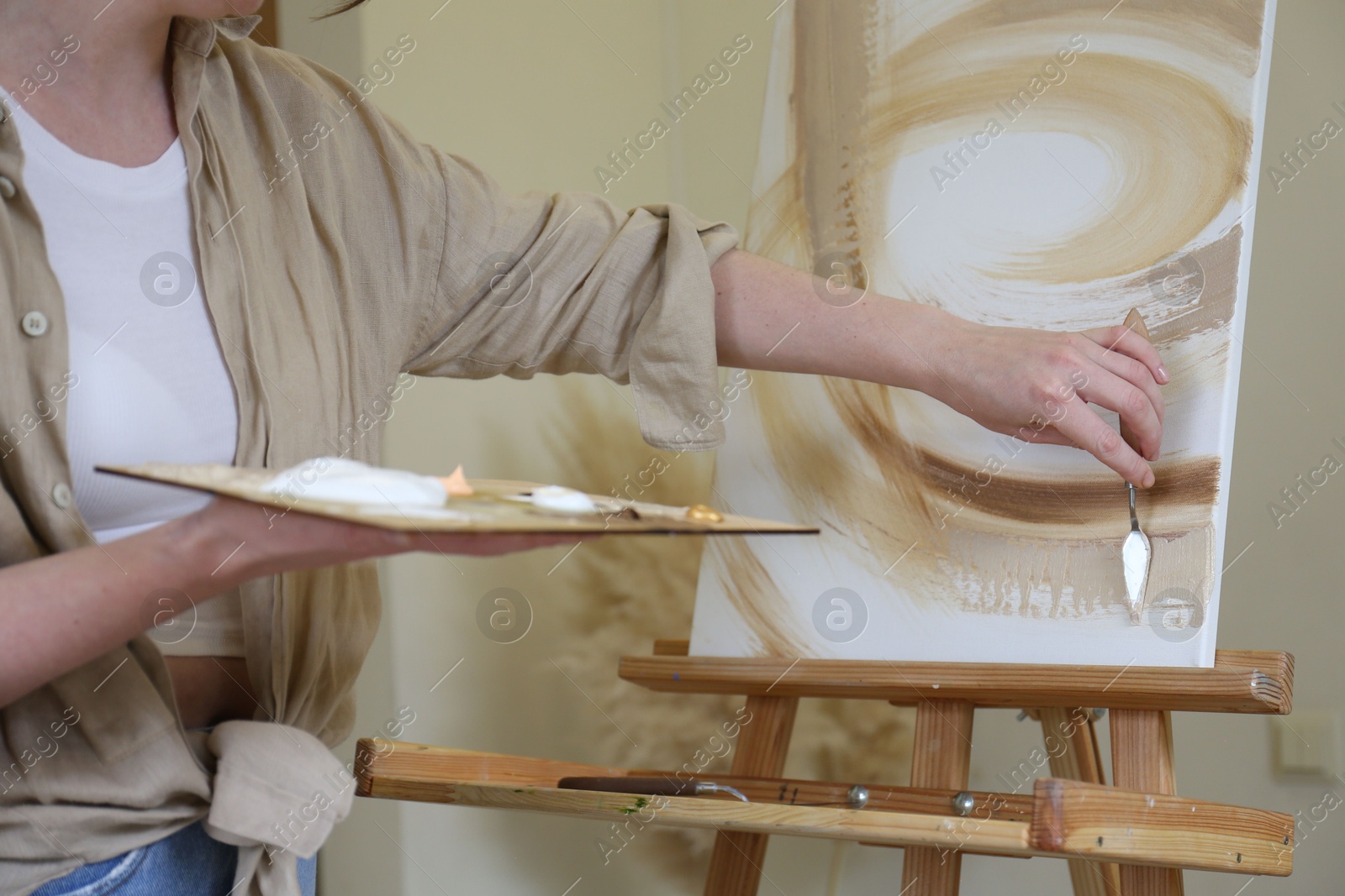 Photo of Woman with palette drawing picture in studio, closeup