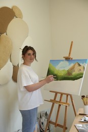 Photo of Woman drawing landscape with brush in studio