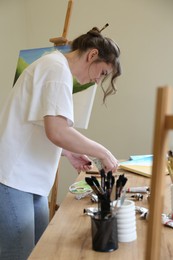 Woman working at wooden table in drawing studio