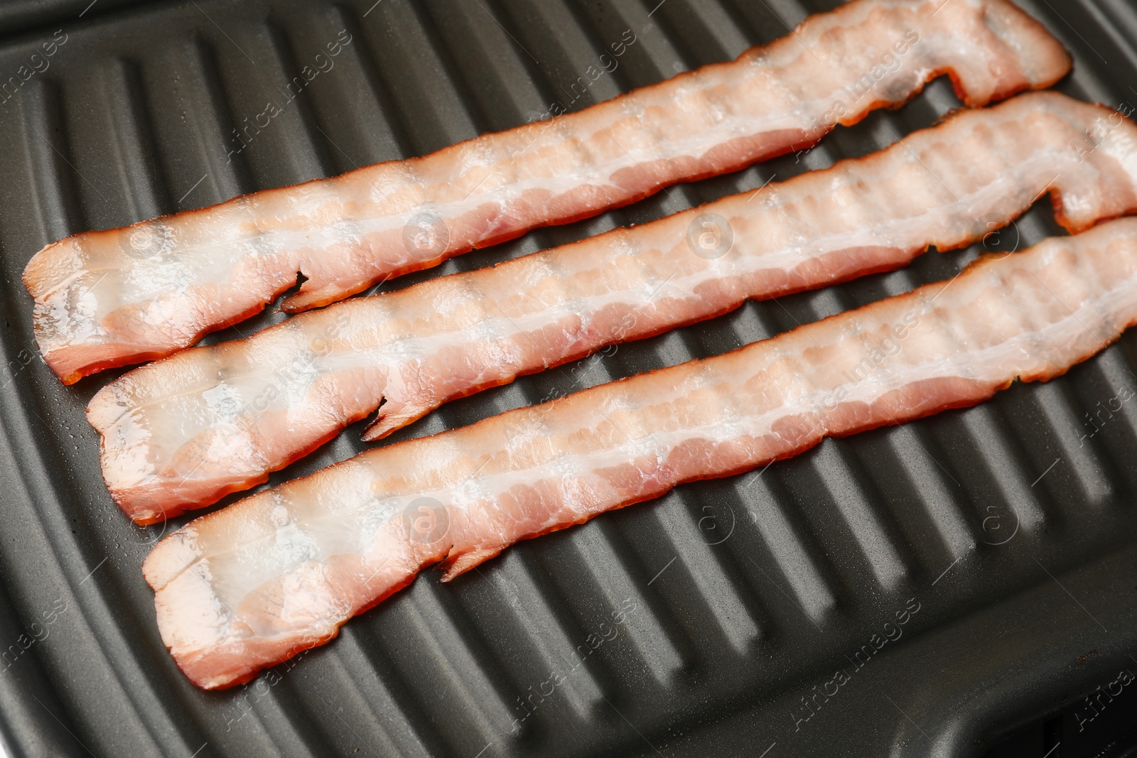 Photo of Slices of bacon on grill, closeup view