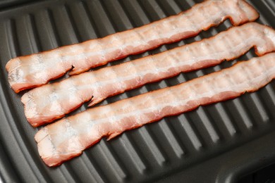 Slices of bacon on grill, closeup view