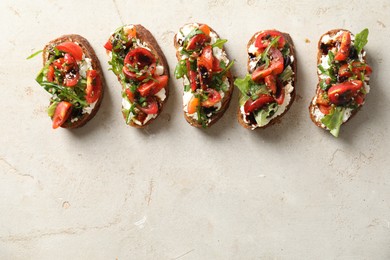 Photo of Delicious bruschettas with ricotta cheese, tomatoes and arugula on light textured table, flat lay. Space for text