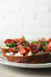 Delicious bruschettas with ricotta cheese, tomatoes, and arugula on light table, closeup. Space for text