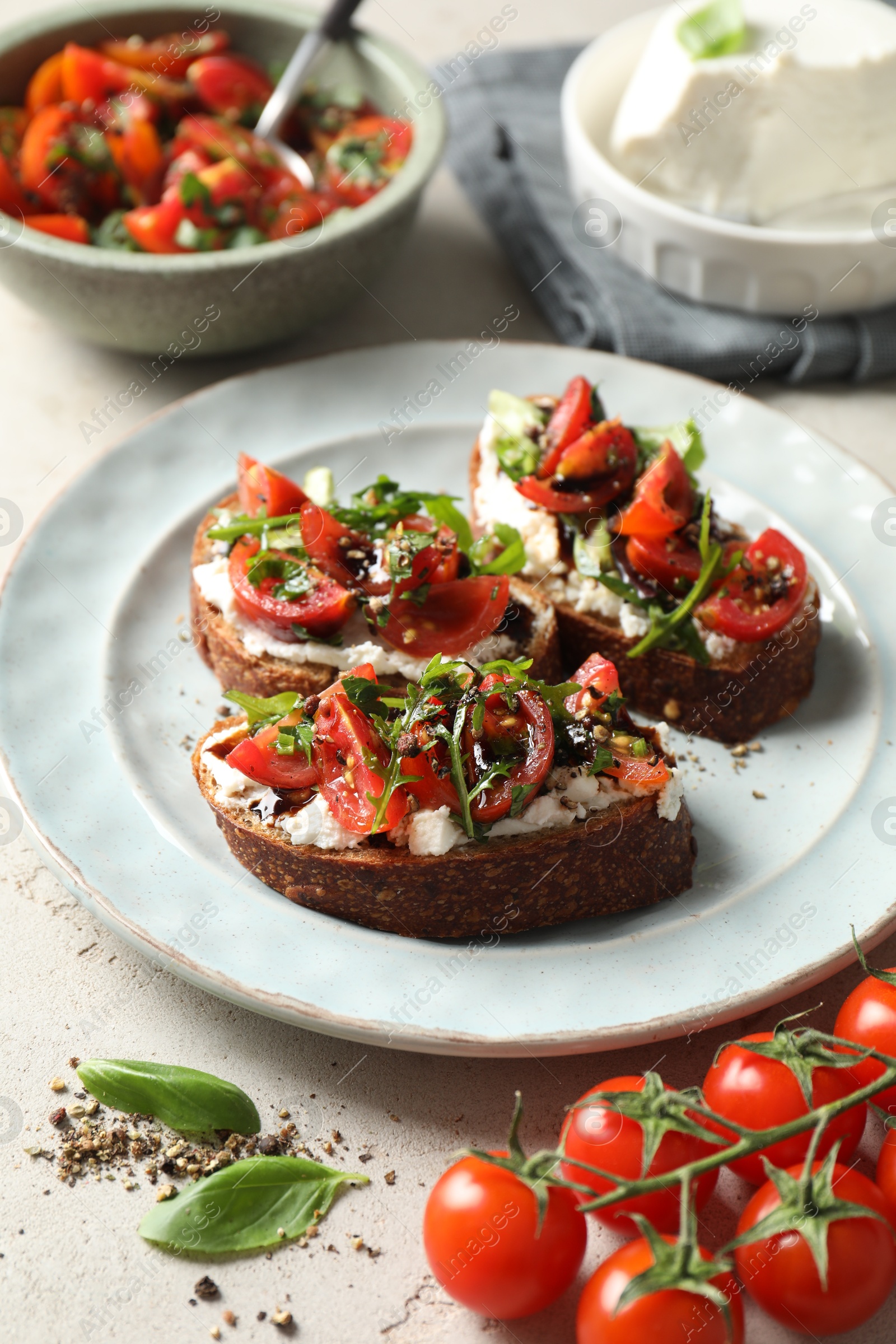 Photo of Delicious bruschettas with ricotta cheese, tomatoes, and arugula on light table