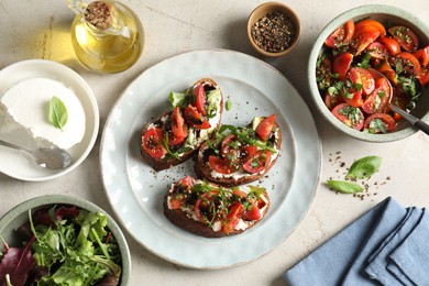 Photo of Delicious bruschettas with ricotta cheese, tomatoes, arugula, salad and peppercorns on light table, flat lay