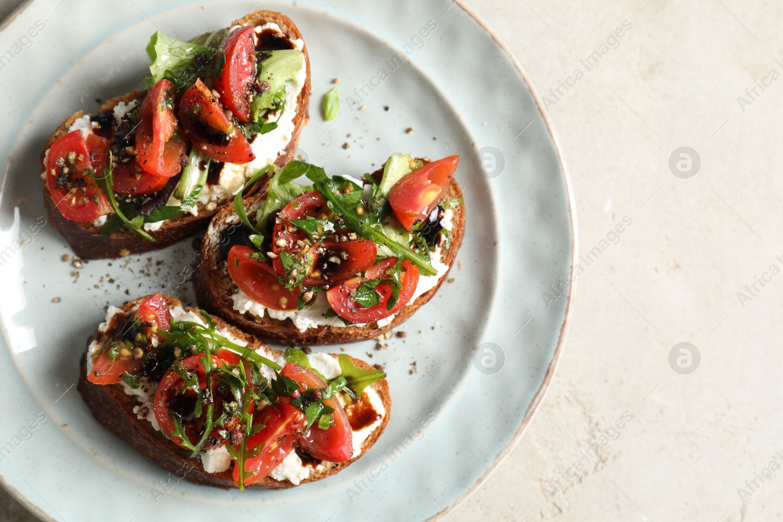 Photo of Delicious bruschettas with ricotta cheese, tomatoes and arugula on light table, top view. Space for text