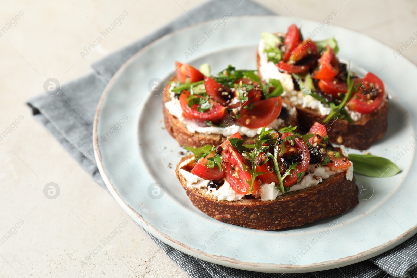 Photo of Delicious bruschettas with ricotta cheese, tomatoes and arugula on light table, closeup