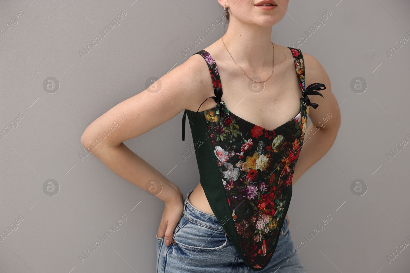 Photo of Woman in stylish corset on grey background, closeup