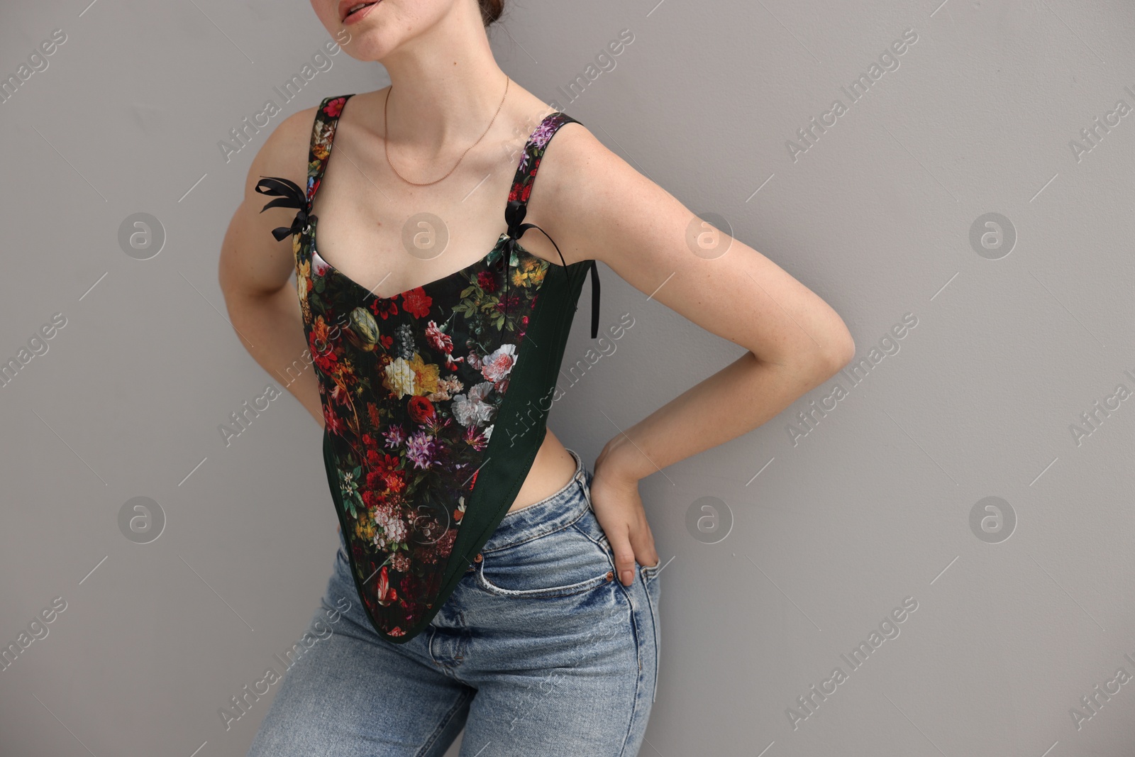 Photo of Woman in stylish corset on grey background, closeup