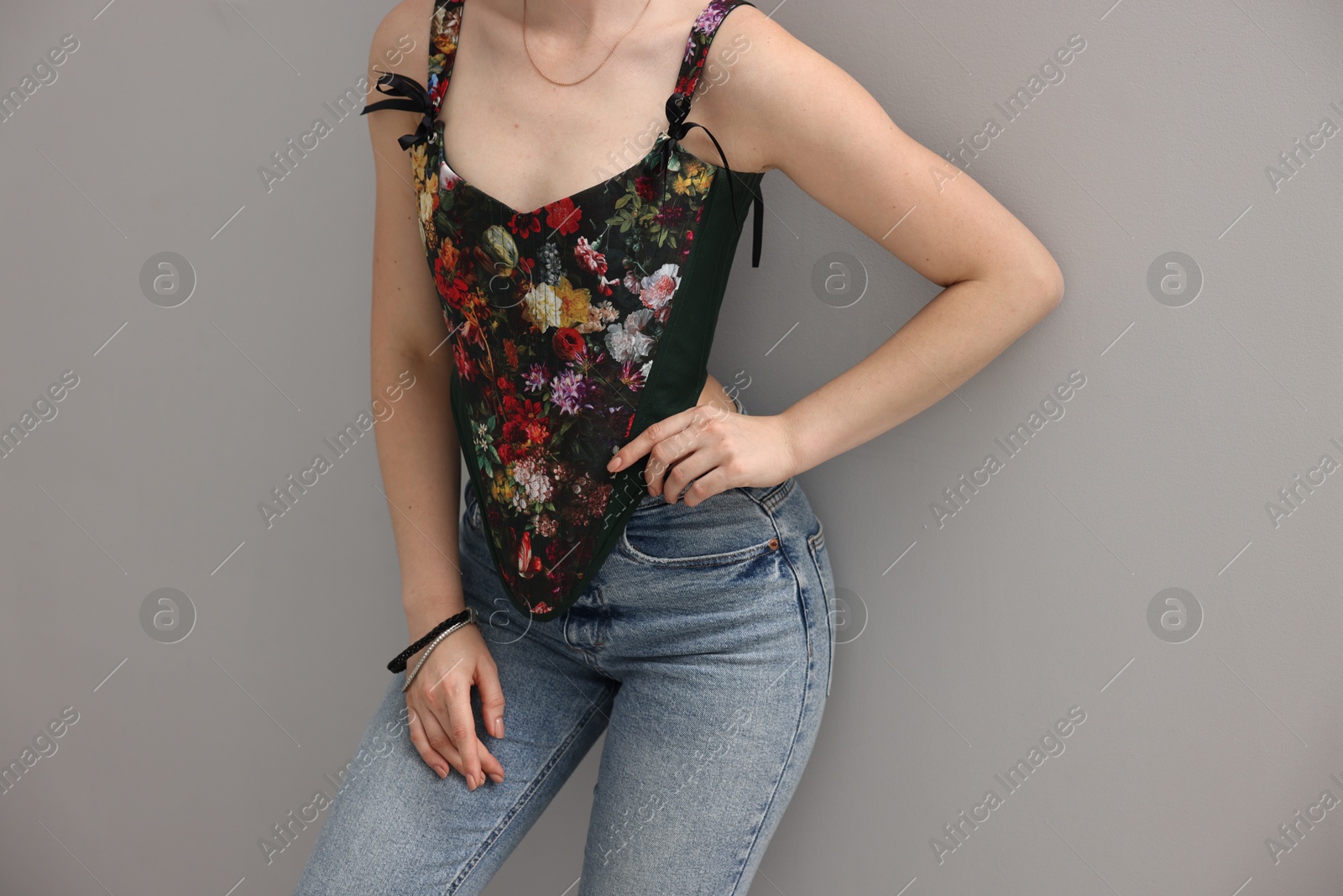 Photo of Woman in stylish corset on grey background, closeup