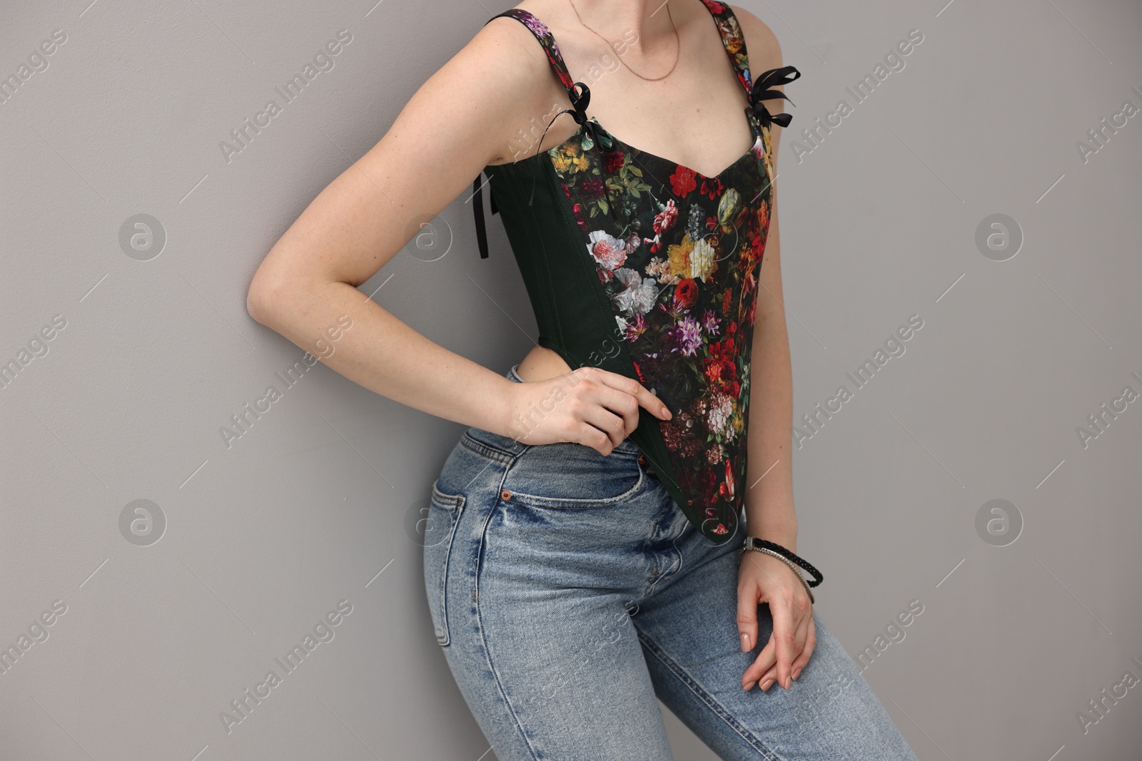 Photo of Woman in stylish corset on grey background, closeup