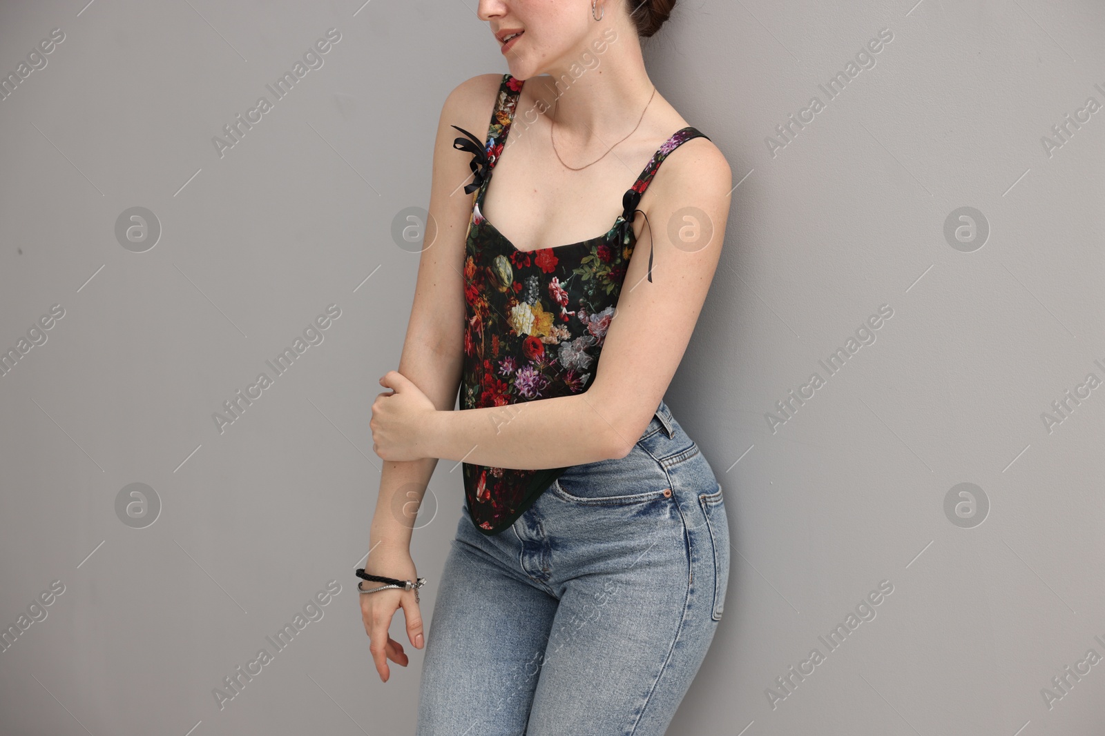 Photo of Woman in stylish corset on grey background, closeup